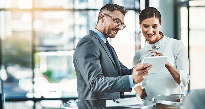 business man and woman looking at tablet